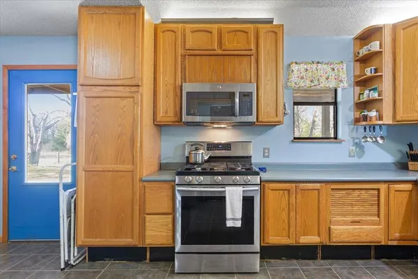 a kitchen with granite countertop cabinets stainless steel appliances and a window