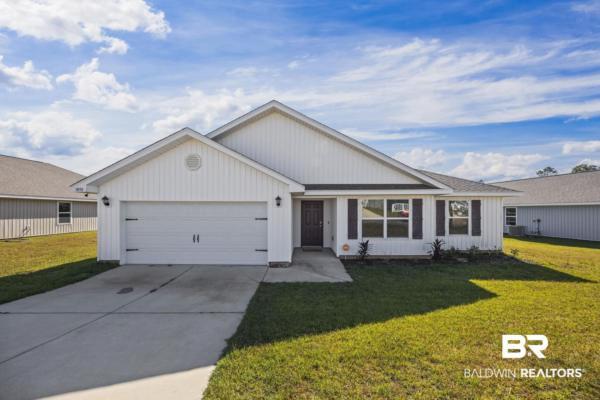 3090 Camino Real Loop Lillian, AL 36549 - Photo 1 of 29 Ranch-style home with concrete driveway, an attached garage, a front lawn, and board and batten siding