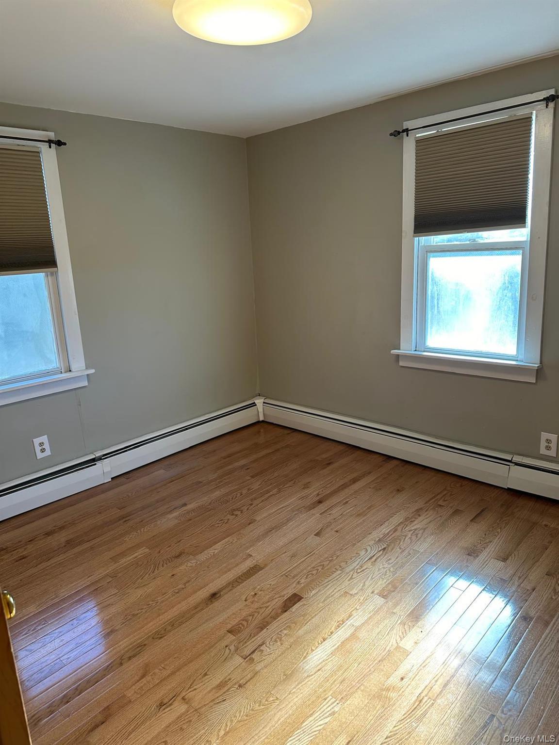 168 Pine Hill Road, Unit 1 Chester, NY 10918 - Photo 9 of 13 Bedroom with a baseboard radiator and light wood -style vinyl flooring