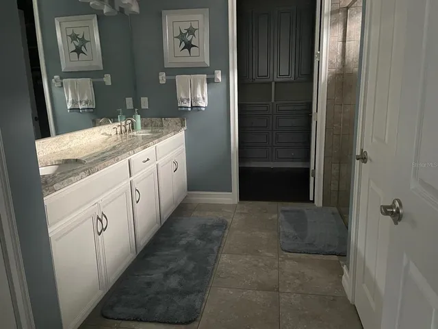 a bathroom with a granite countertop sink a toilet and shower