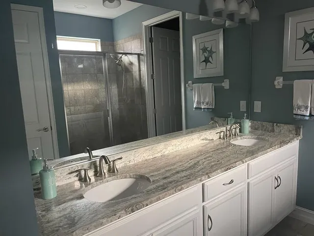 a bathroom with double vanity sinks and a mirror