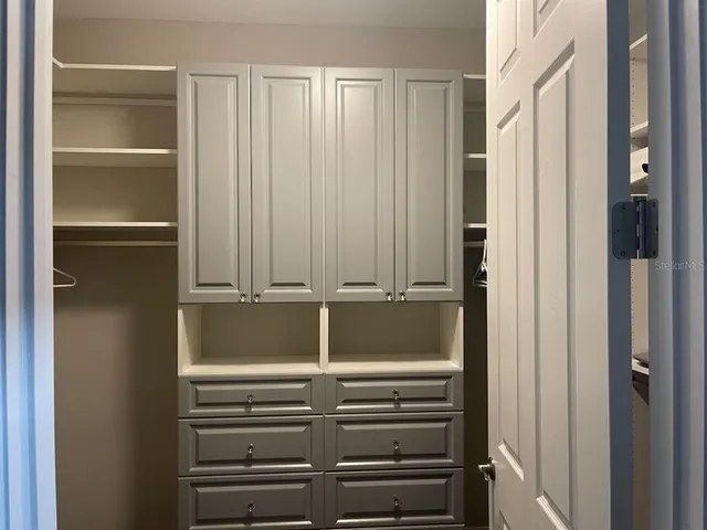 a view of walk in closet with empty racks