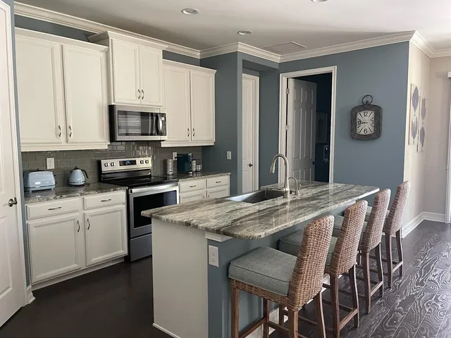 a kitchen with stainless steel appliances granite countertop a stove a sink island and a refrigerator