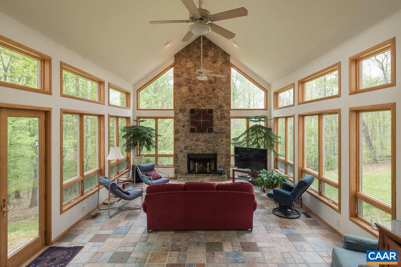 680 Broad Axe Road Charlottesville, VA 22903 - Photo 7 of 19 a living room with furniture a fireplace and a floor to ceiling window
