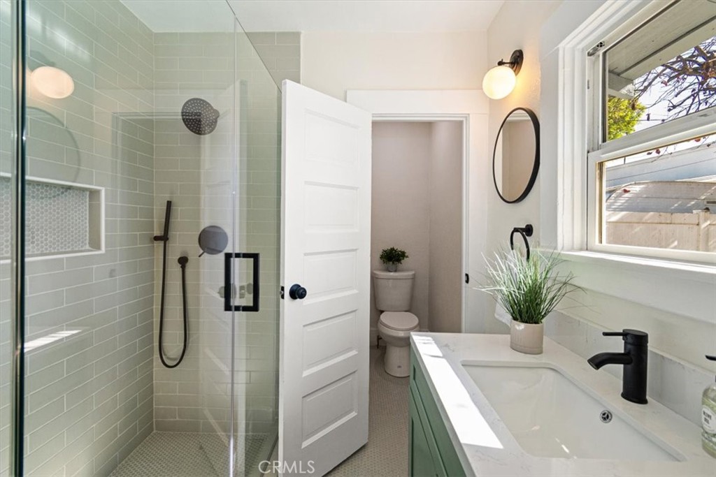 4474 Highland Place Riverside, CA 92506 - Photo 23 of 31 a bathroom with a granite countertop shower a mirror and a sink