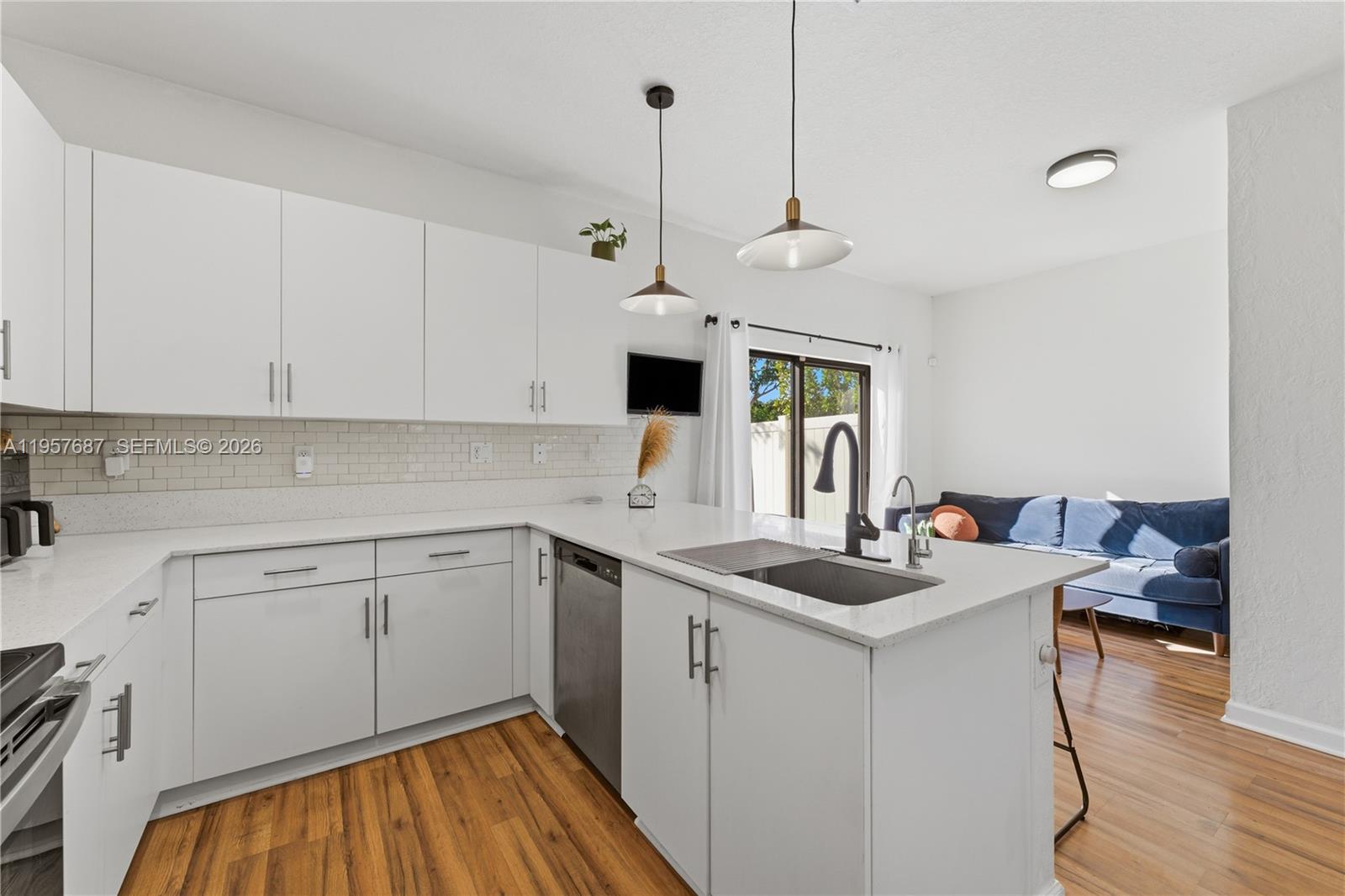 11456 West 33rd Way Hialeah, FL 33018 - Photo 11 of 49 a kitchen that has a cabinets a sink and a stove with wooden floor