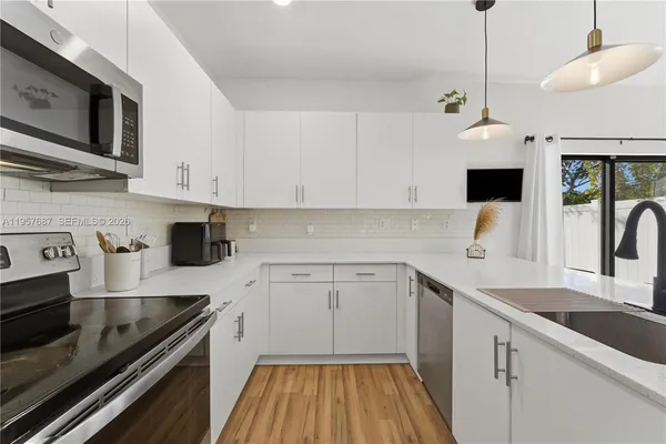 a kitchen with a sink stove and cabinets