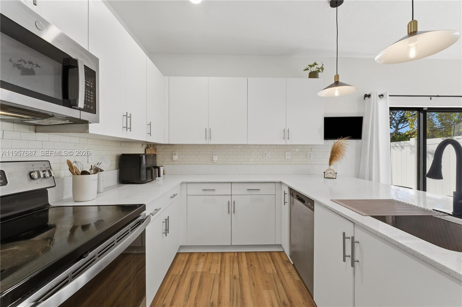 11456 West 33rd Way Hialeah, FL 33018 - Photo 13 of 49 a kitchen with a sink stove and cabinets