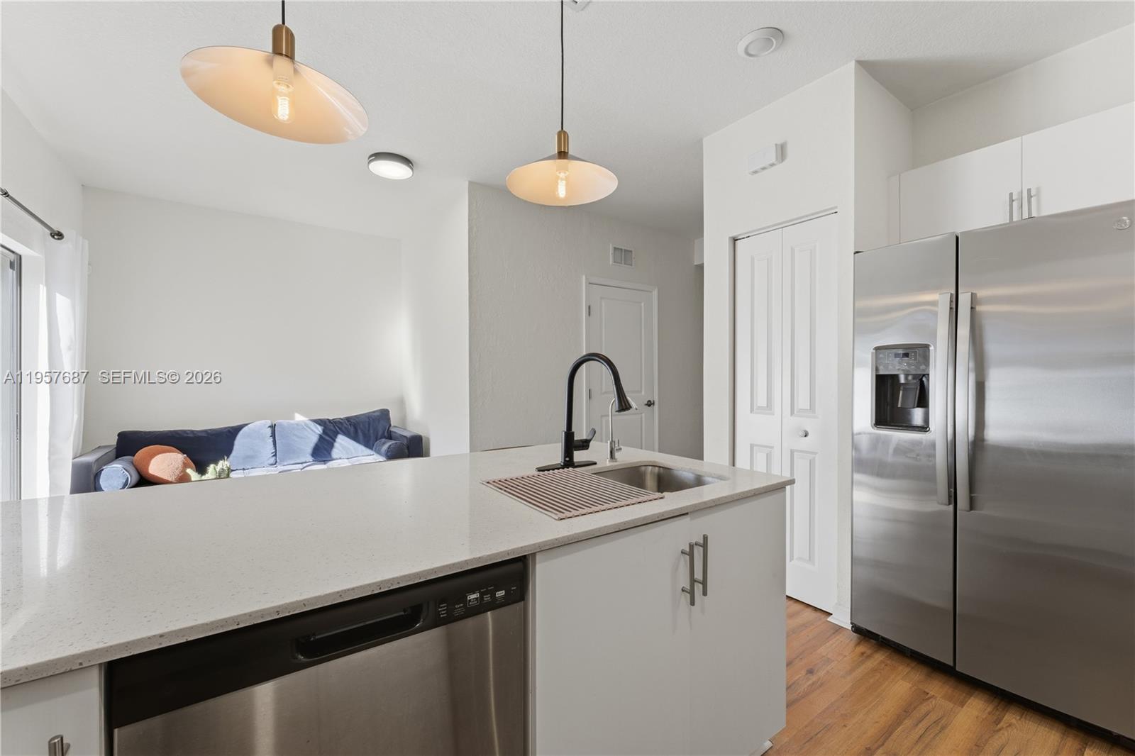 11456 West 33rd Way Hialeah, FL 33018 - Photo 15 of 49 a kitchen with stainless steel appliances a sink refrigerator and a wooden floor