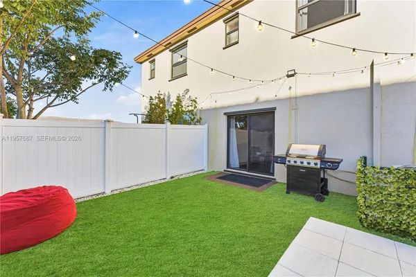 a backyard of a house with a garden and barbeque oven