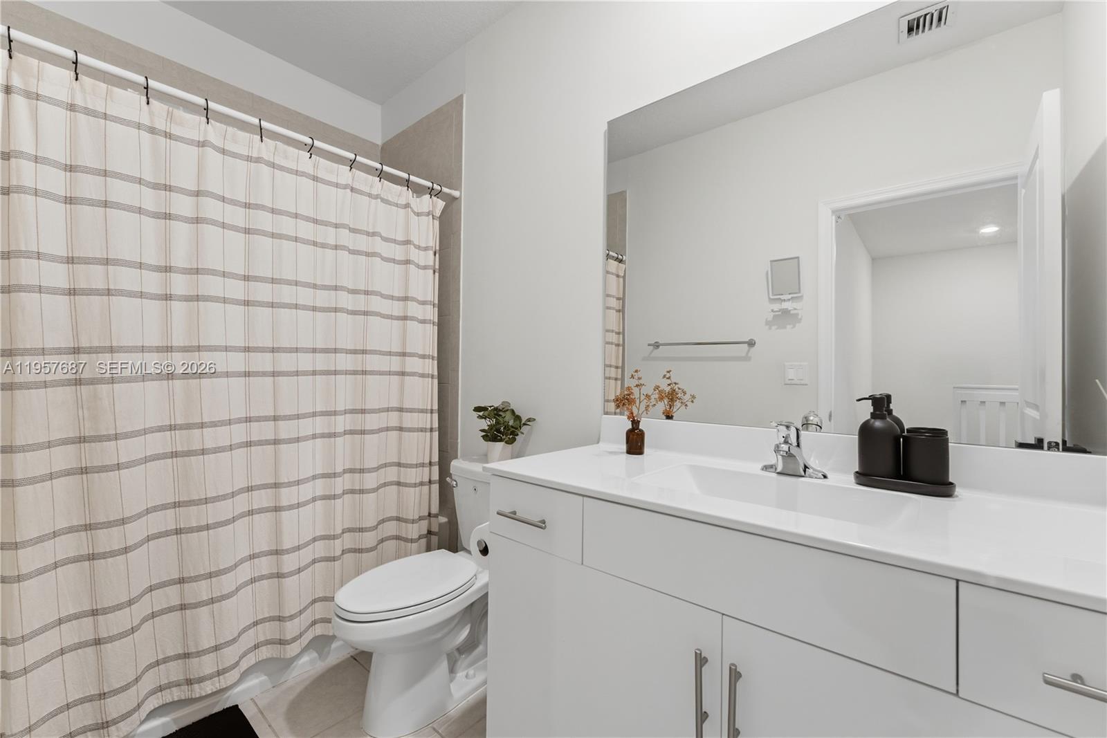 11456 West 33rd Way Hialeah, FL 33018 - Photo 23 of 49 a bathroom with a sink a toilet and shower curtain