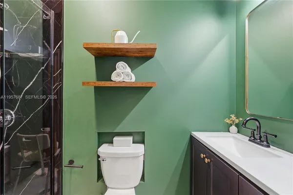 a bathroom with a toilet sink and mirror