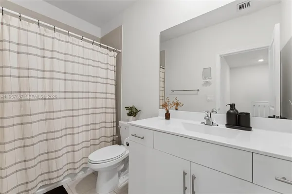 a bathroom with a sink a toilet and shower curtain