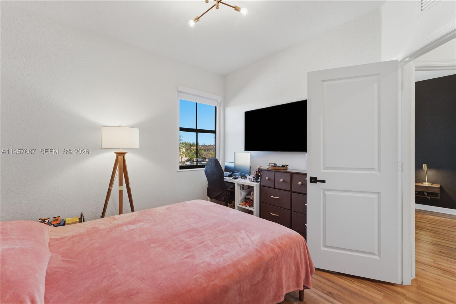 11456 West 33rd Way Hialeah, FL 33018 - Photo 27 of 49 a bedroom with a bed and a flat tv screen on dresser