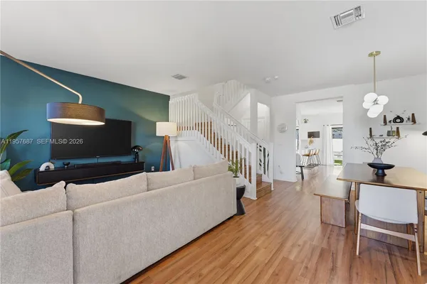 a living room with furniture and a wooden floor