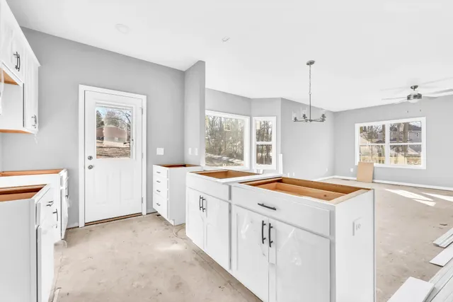a kitchen with granite countertop a sink stove and cabinets