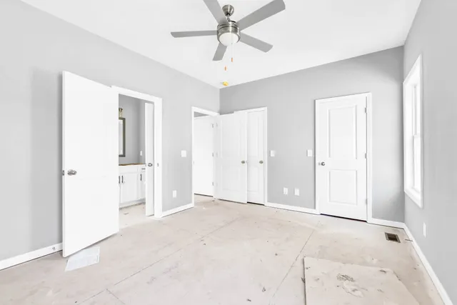 an empty room with fan and entrance