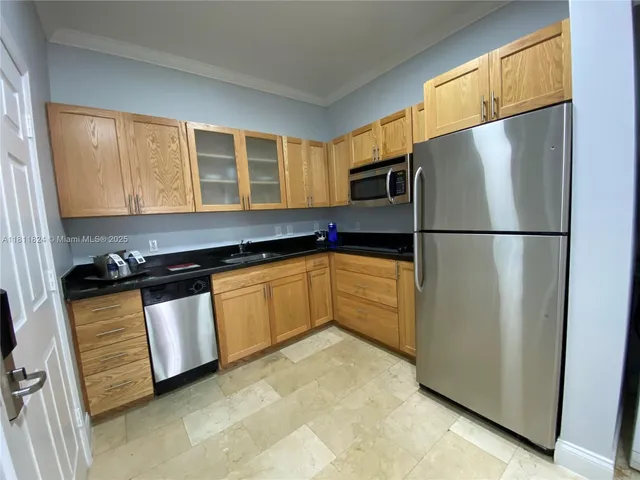 a kitchen with stainless steel appliances granite countertop a refrigerator a sink and a stove