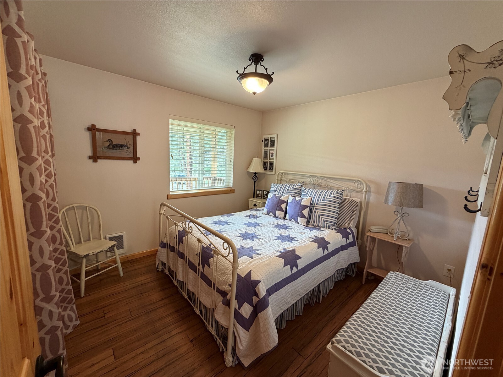 53 Cape Labelle Road Tonasket, WA 98855 - Photo 13 of 40 a bed sitting in a bedroom next to a window and a chandelier