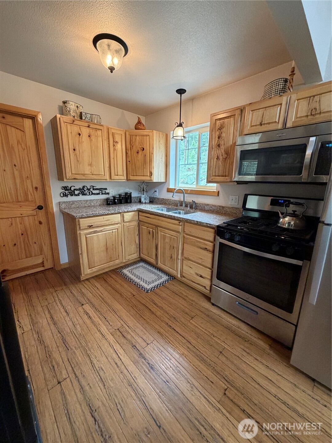 53 Cape Labelle Road Tonasket, WA 98855 - Photo 32 of 40 a kitchen with wooden cabinets and a stove top oven