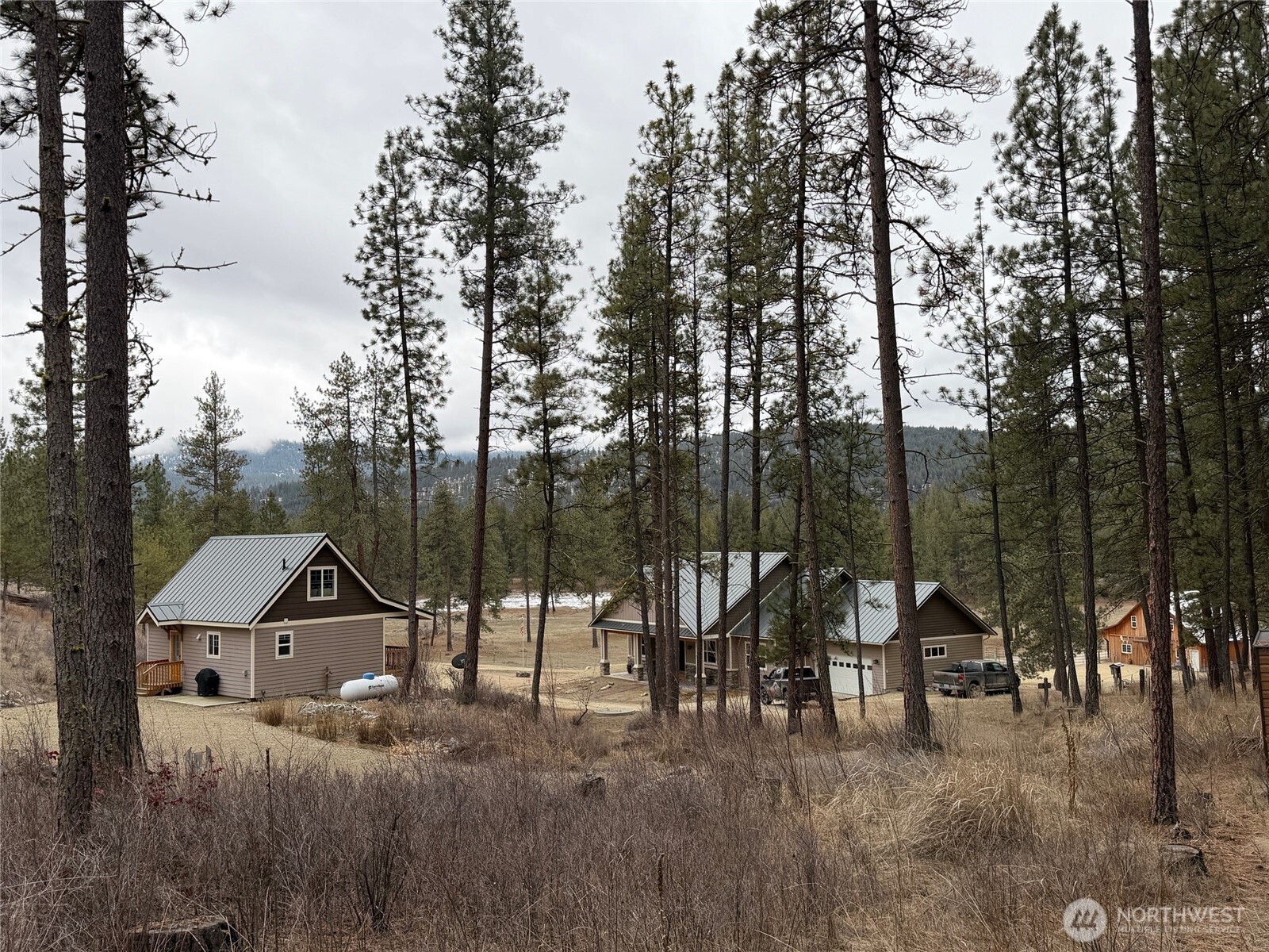 53 Cape Labelle Road Tonasket, WA 98855 - Photo 36 of 40 a view of a town with large trees and wooden fence