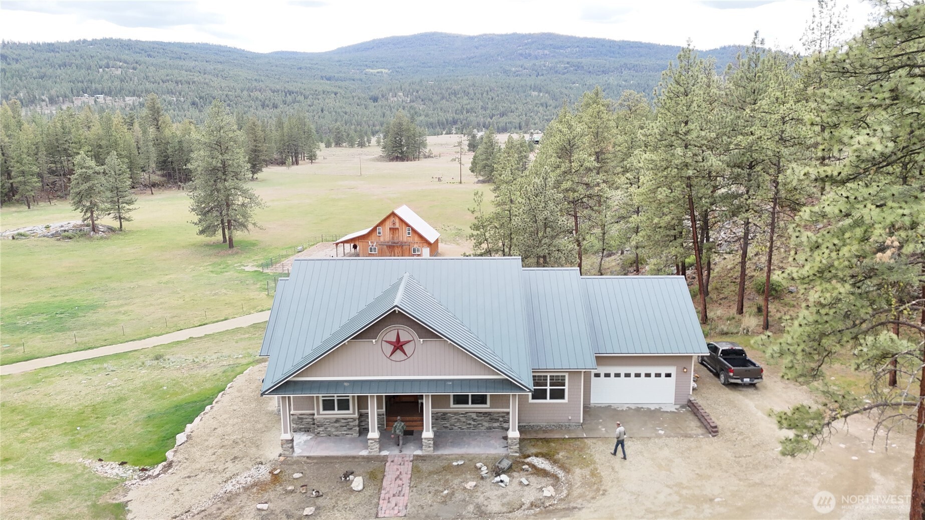 53 Cape Labelle Road Tonasket, WA 98855 - Photo 7 of 40 a view of a large house with a yard and mountain view