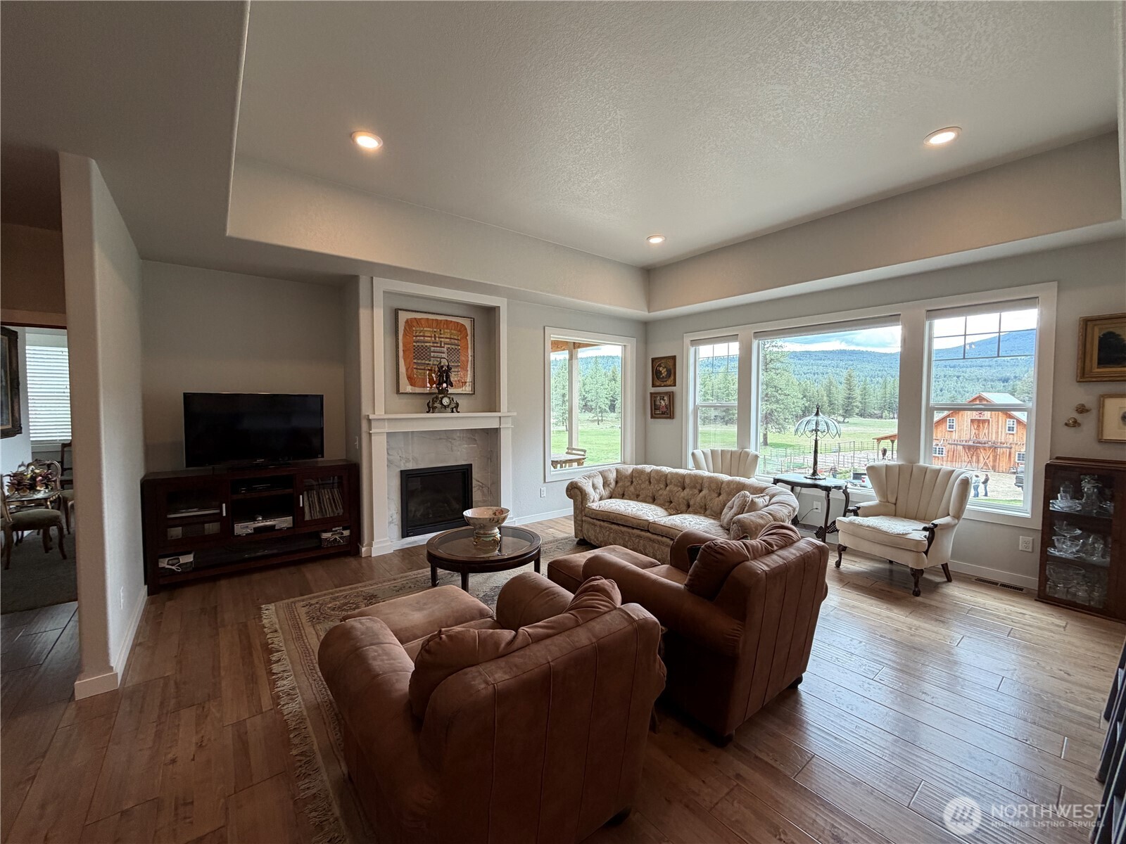 53 Cape Labelle Road Tonasket, WA 98855 - Photo 9 of 40 a living room with fireplace furniture and a flat screen tv
