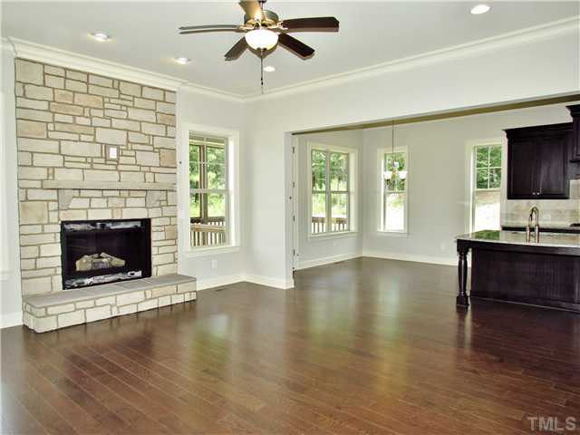 3204 Bryant Falls Court, Unit LOT58 Raleigh, NC 27613 - Photo 5 of 25 a view of a livingroom with furniture a fireplace wooden floor and chandelier