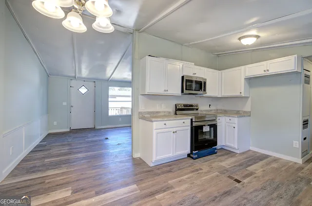 a kitchen with stainless steel appliances granite countertop a stove and a microwave