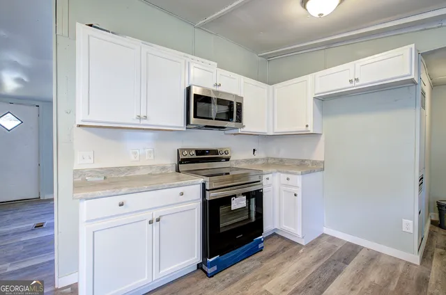 a kitchen with granite countertop a stove a sink and a chandelier