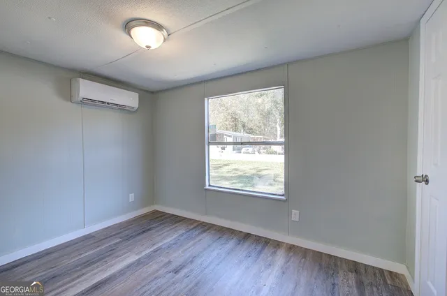 a view of an empty room with wooden floor