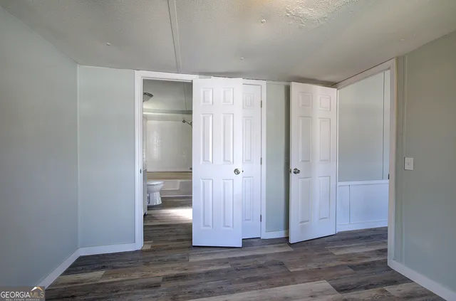 a bathroom with a granite countertop sink toilet a mirror and bathtub