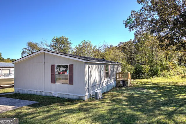 a view of a house with backyard and trees