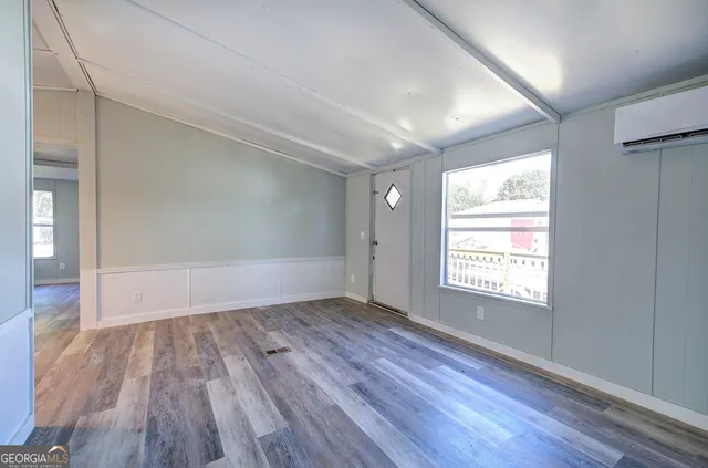 an empty room with wooden floor and window