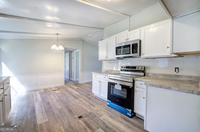 a view of empty room with wooden floor and window