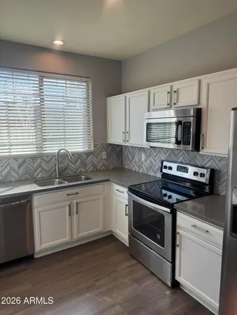 a kitchen with cabinets appliances and a window