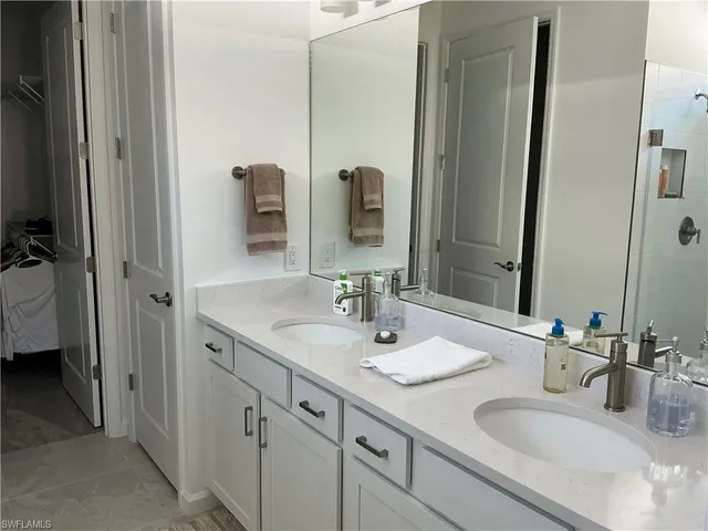 a bedroom with a bed and a flat tv screen on dresser