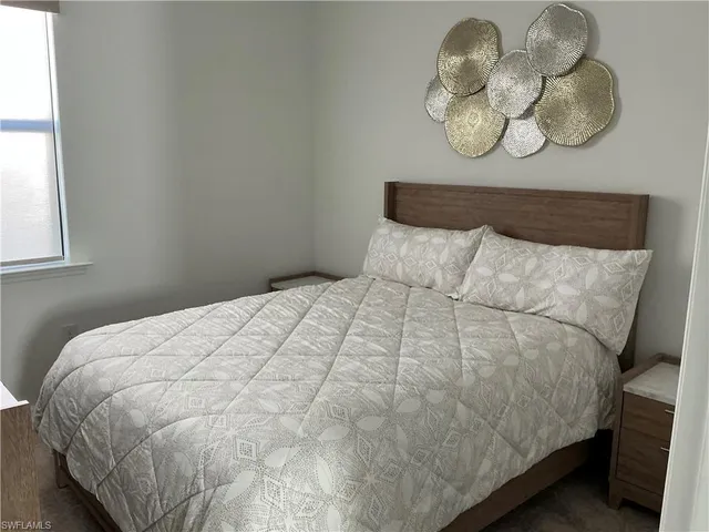 a bedroom with a bed and a flat tv screen on a dresser