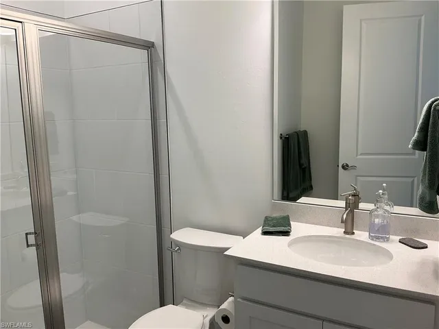 a large bed sitting in a bedroom next to a window and a chandelier