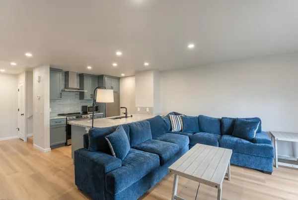 a view of kitchen with kitchen island stainless steel appliances wooden cabinets and couch