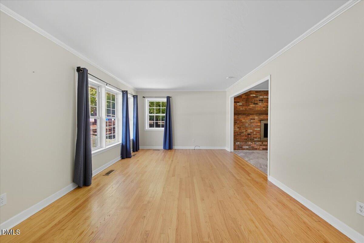 2604 Huntington Road Fayetteville, NC 28303 - Photo 12 of 48 a view of an empty room with wooden floor and a window