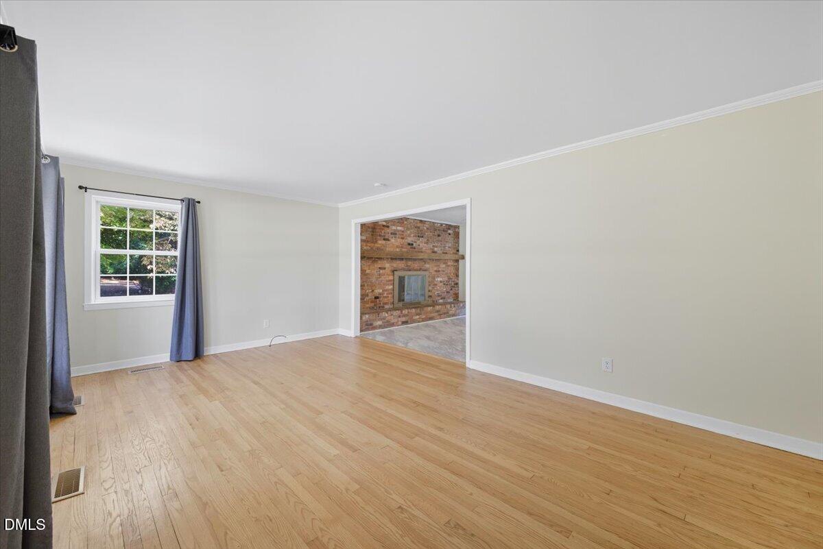 2604 Huntington Road Fayetteville, NC 28303 - Photo 13 of 48 a view of an empty room with wooden floor and a window