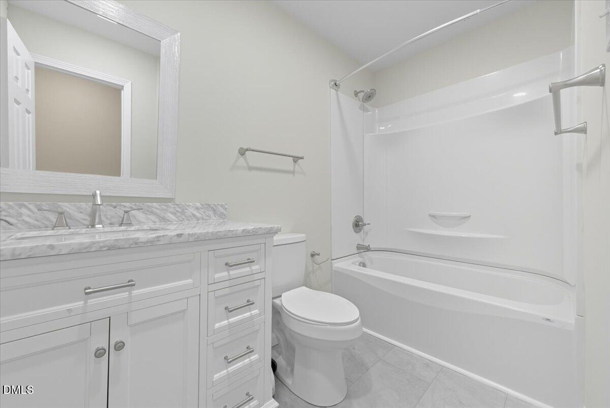 2604 Huntington Road Fayetteville, NC 28303 - Photo 27 of 48 a bathroom with a granite countertop toilet a sink and a bathtub