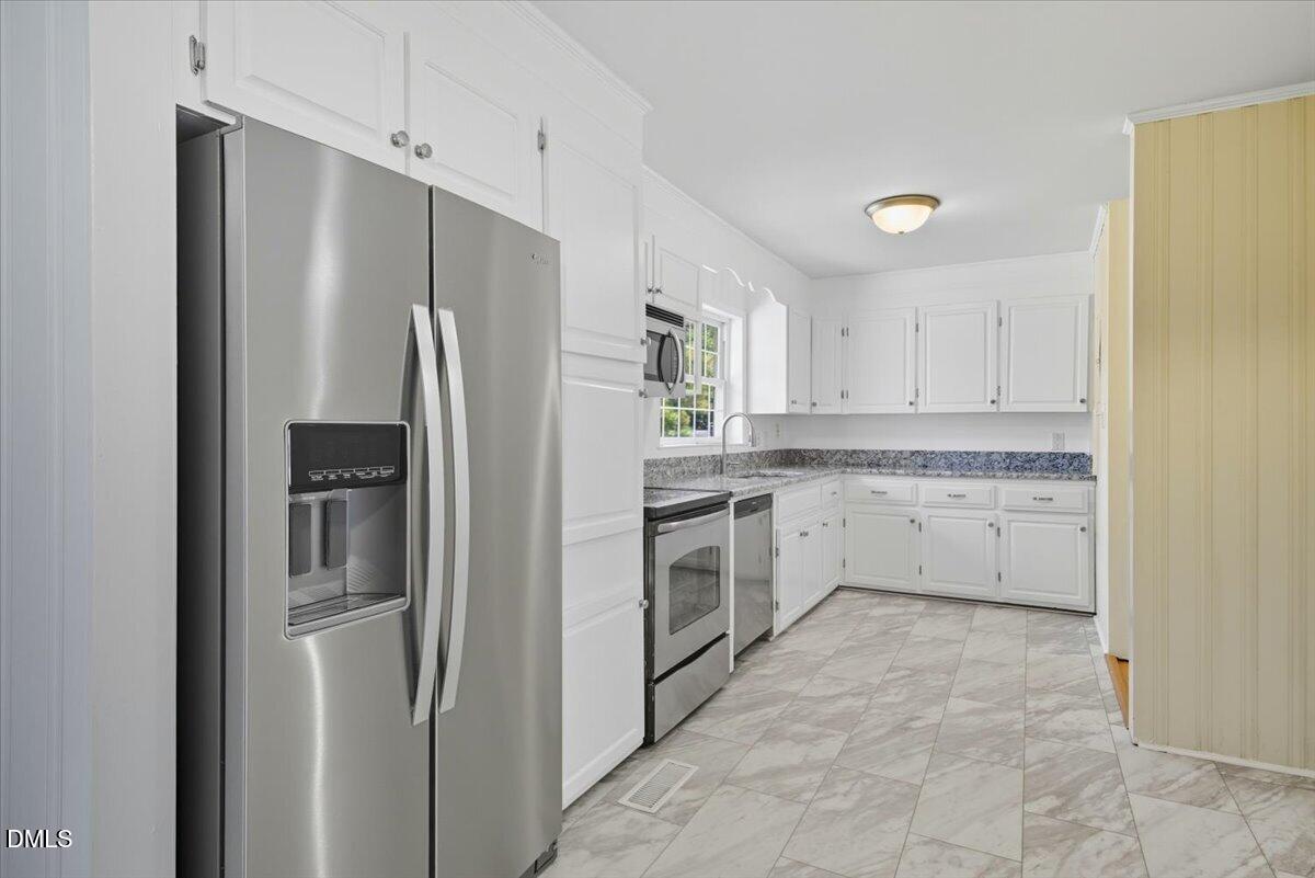 2604 Huntington Road Fayetteville, NC 28303 - Photo 8 of 48 a kitchen with a refrigerator sink and cabinets