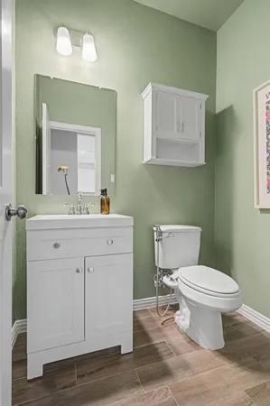 a bathroom with a toilet sink and mirror