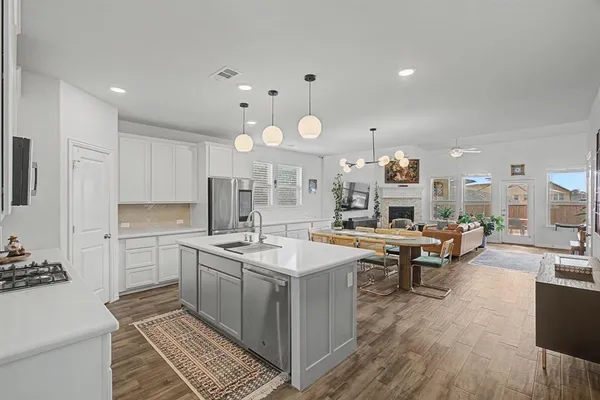 a large white kitchen with lots of counter space and furniture
