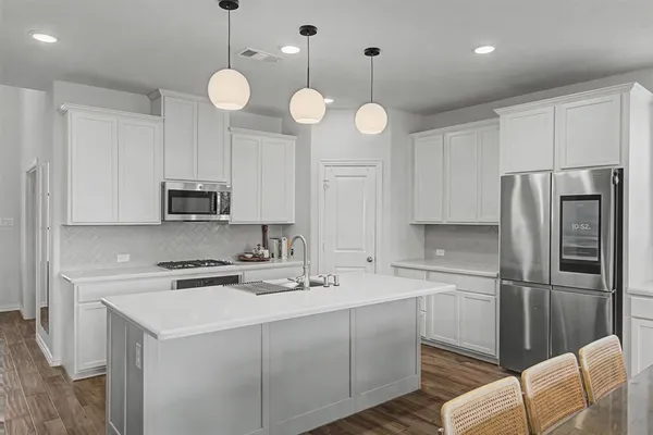 a kitchen with stainless steel appliances a stove a sink and cabinets