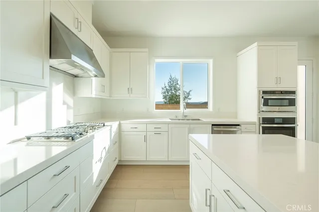 a kitchen with granite countertop a sink stove and cabinets