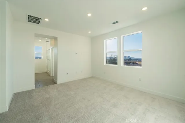 an empty room with windows and closet