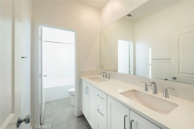 a bathroom with a double vanity sink and a mirror
